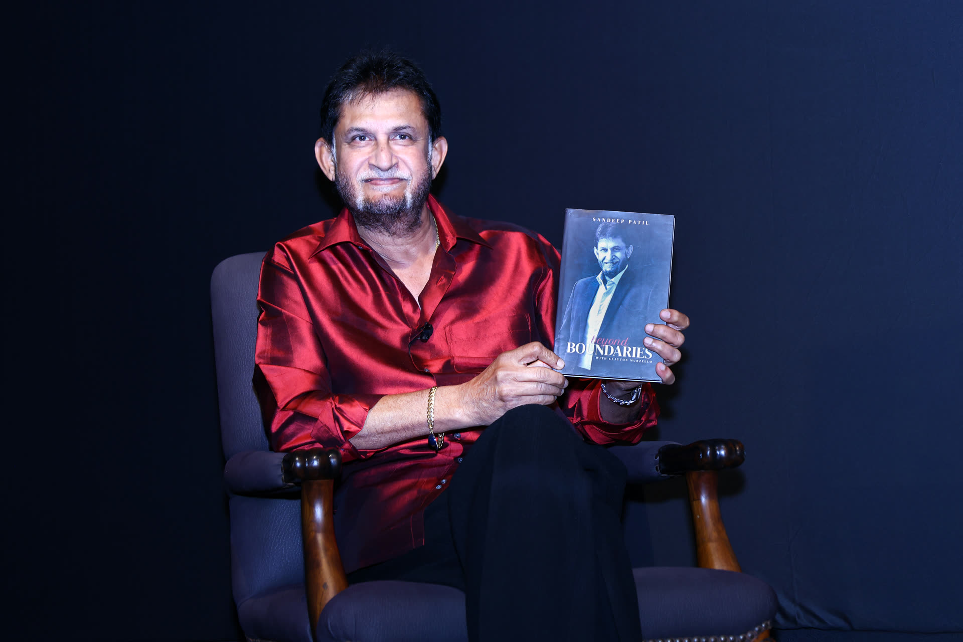 Sandeep Patil holding his book Beyond Boundaries at a Club evening